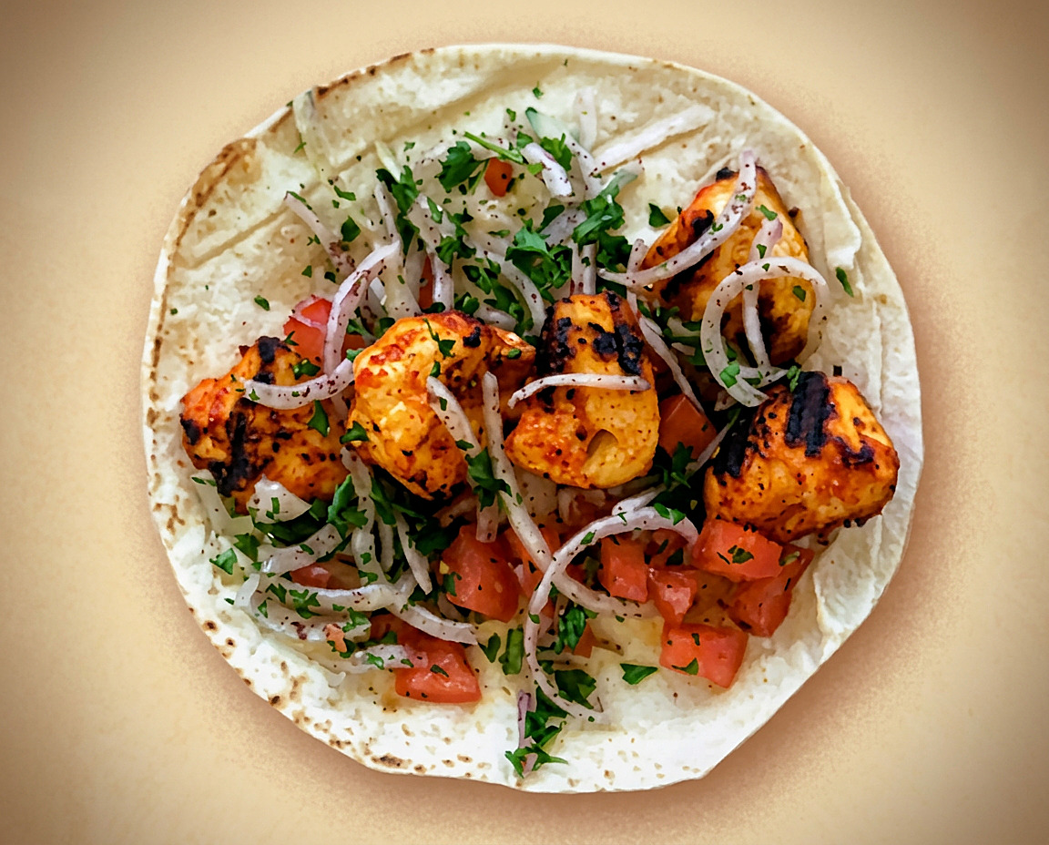 Chicken kebab pita sandwich with onions and tomato