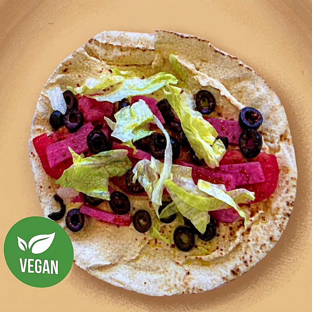 Vegan hummos pita with pickled turnips, olives and lettuce